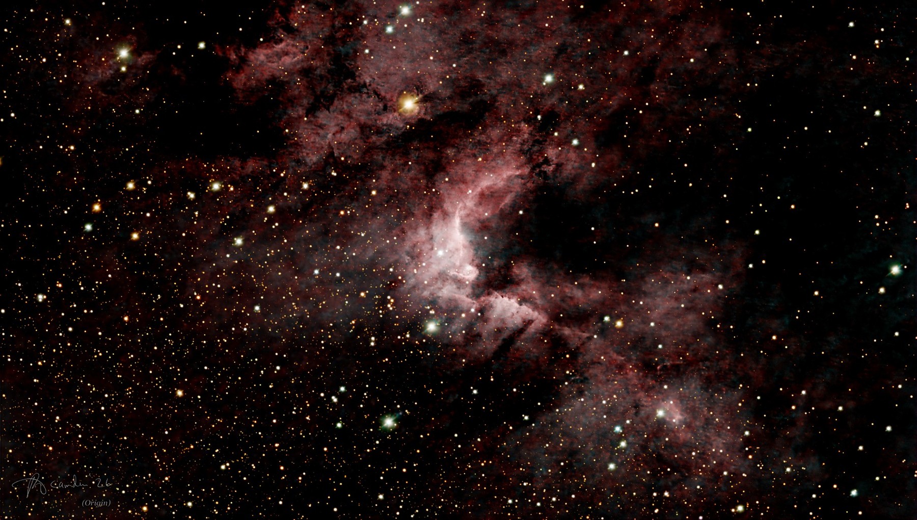The Cave Nebula, Sh2-155 — a bright white and pink rim of glowing gas beside a dark lane of dust, in a field laced with faint red hydrogen and orange, white and blue stars