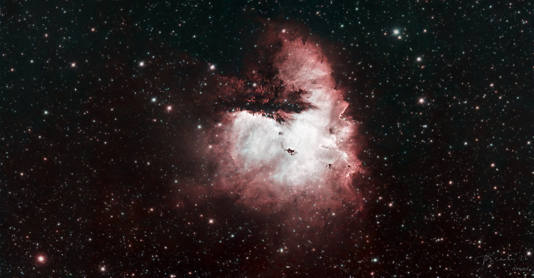 The Pacman Nebula, NGC 281 — a glowing red and white cloud with a dark dust lane forming the mouth, in a dense star field