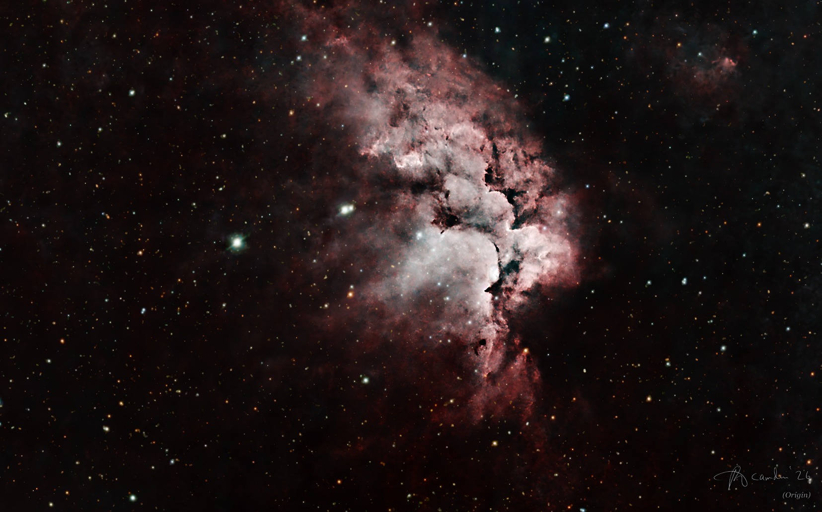 The Wizard Nebula, NGC 7380 — a glowing pink and white cloud carved by dark pillars of dust, in a field of orange, white and blue stars
